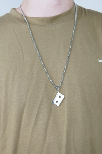 Hip-hop retro cassette tape pendant necklace in polished steel worn on olive t-shirt