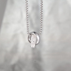 Macro shot of interlocking silver rings with pavé cubic zirconia on a box chain necklace