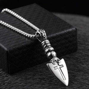 Detail of vintage arrow pendant with cross engraving on stainless steel bead chain