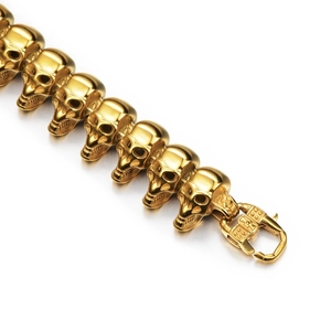 Detailed view of golden hiphop skull link bracelet with a decorative lobster clasp