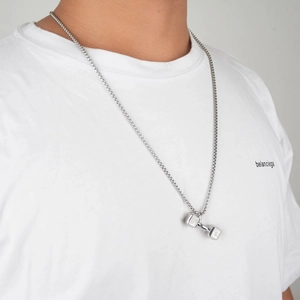 Polished stainless steel dumbbell pendant necklace on male model wearing a white tee