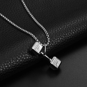 Detail of silver dumbbell necklace with 50KG engraving on textured black leather