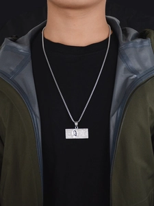 Detailansicht einer silbernen Hip-Hop-Halskette mit 100-Dollar-Anhänger an einem Model