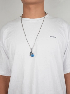 Detalle del collar hiphop de garra de dragón con colgante de cuenta azul y cadena de acero