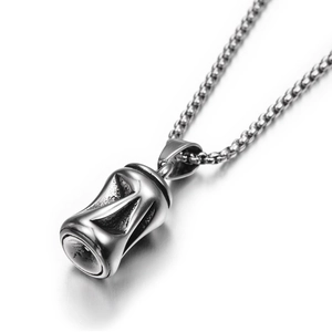 Vue macro d'un pendentif en titane argenté à texture industrielle sur chaîne à billes