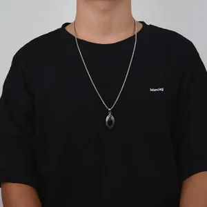 Detail of a hip-hop style oval black gemstone pendant on a silver box chain necklace