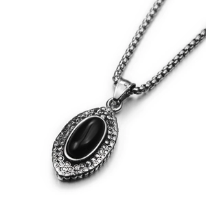 Macro detail of marquise black onyx pendant with textured silver border and box chain