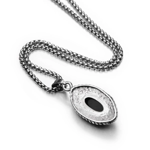Macro shot of a vintage oval pendant featuring a black gemstone and a silver textured frame