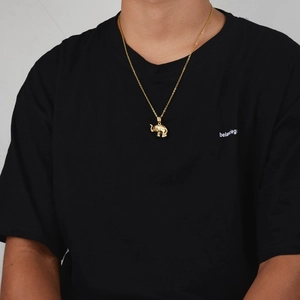 Détail d'un collier pendentif éléphant doré de style hip hop sur un t-shirt noir