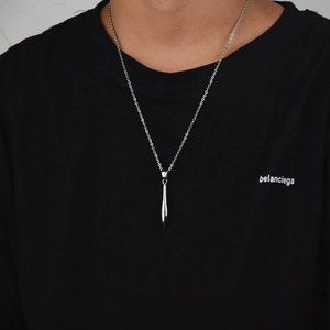Polished silver torpedo cone pendant on a fine link chain worn by male model