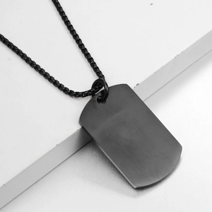 Detail of matte black industrial style rectangular tag necklace with brushed metal finish