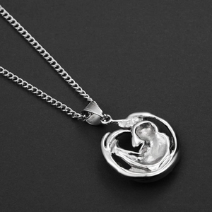 Close-up of hip-hop titanium steel necklace featuring an abstract silver embrace pendant