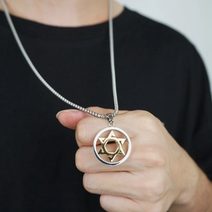 Détail d'un pendentif hexagramme bicolore or et argent avec une chaîne à billes d'acier