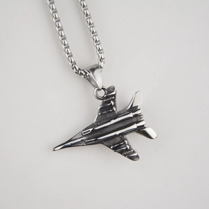 Gros plan du pendentif avion de chasse en acier avec finition vintage et chaîne