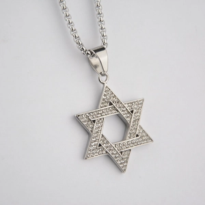 Macro view of silver star of David pendant with pavé set crystals on a box chain