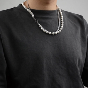 Hip-hop style layered pearl and silver metal chain necklace worn by a fashion model