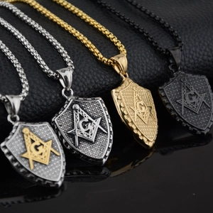 Détail macro de pendentifs bouclier franc-maçon en quatre finitions sur cuir