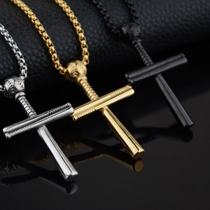 Vue macro de pendentifs croix baseball en argent, or et noir sur des chaînes à perles