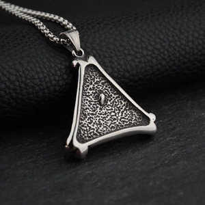 Triangle titanium steel necklace with vintage textured pendant on a black stone surface