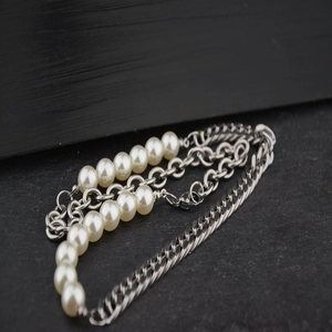 Mehrlagige Perlenkette aus Stahl mit weißen Perlen und Metallketten im Industrial-Stil