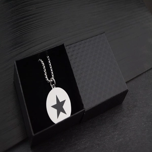 Collier minimaliste en acier titane avec pendentif étoile dans son coffret cadeau noir