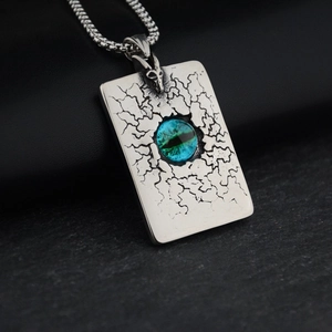 Détail macro du pendentif carré œil gothique avec pierre bleue et texture vintage