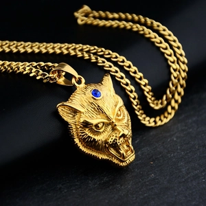 Detailed close-up of gold leopard head pendant with blue gemstone and cuban link chain