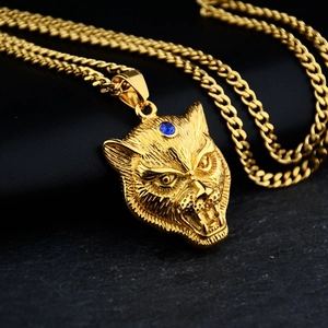 Close-up of golden leopard head pendant with blue crystal on textured stone base