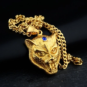 Detailed macro view of a gold leopard head pendant featuring blue sapphire eye accents