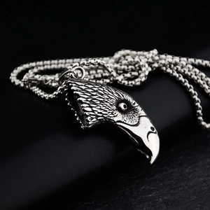 Close-up of vintage silver eagle head pendant with detailed feather textures and bead chain