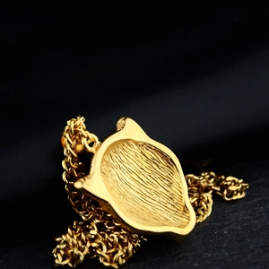 Polished gold leopard head necklace with textured pendant back and thick woven chain