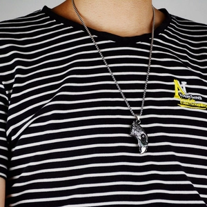 Detail of vintage eagle head pendant necklace worn on a person with retro silver finish