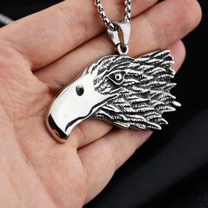 Macro shot of a vintage eagle head pendant in titanium steel held by hand