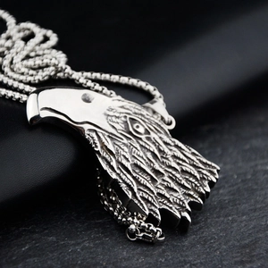 Detailed close-up of eagle head pendant in polished titanium steel with punk style chain