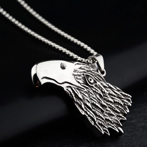 Macro view of vintage silver eagle head pendant with detailed feather carving on metal chain