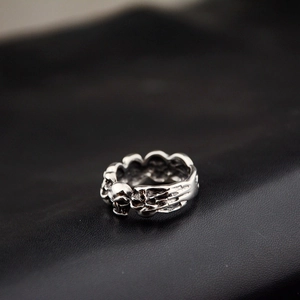 Makroansicht des Vintage-Silber-Totenkopfrings mit gotischen Knochendetails auf Leder