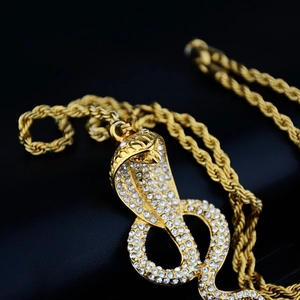 Hip-hop gold cobra necklace with sparkling zircons on twisted rope chain over black leather