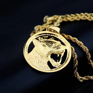 Gros plan du pendentif tête de léopard plaqué or avec une grosse chaîne de style corde