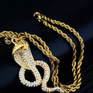 Macro shot of hip-hop gold cobra pendant fully inlaid with sparkling diamonds and rope chain