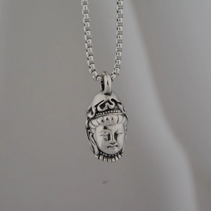 Detailed view of silver Guanyin Buddha head pendant with vintage oxidation on square box chain
