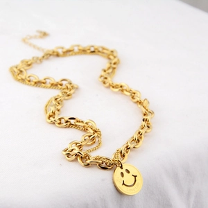 Detail of gold double-layer chain necklace with smiley face pendant and Love Life engraving