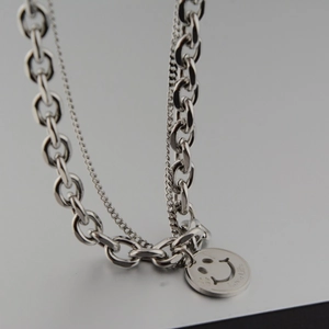 Detail view of silver layered necklace with smiley face pendant and Love Life engraving