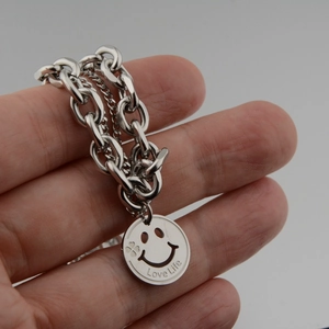 Double-layered silver necklace featuring a smiling face pendant and Love Life engraving