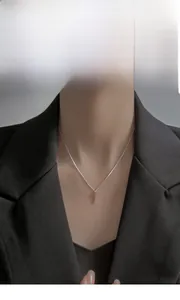 Silver cross pendant necklace on neck, minimalist punk style with O-chain and dark suit