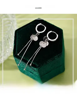 Detail of S925 sterling silver drop earrings with discs on a green velvet box