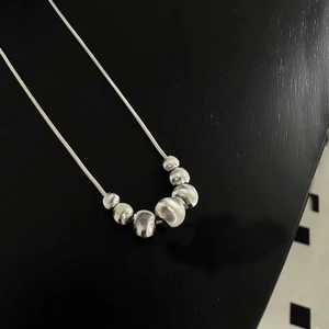 Detail of S925 sterling silver snake chain necklace with seven brushed metal cat eye beads