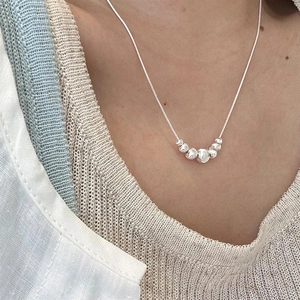 Close-up of S925 sterling silver snake chain necklace with seven gradient round beads