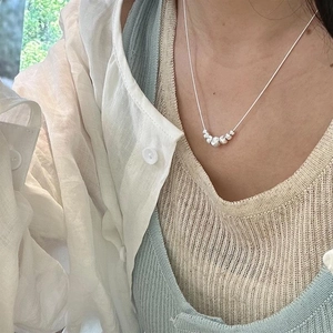 Detail of S925 sterling silver snake chain necklace with gradient cat-eye beads on model