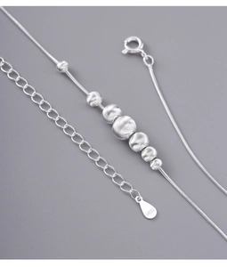 Macro shot of S925 sterling silver beads with brushed texture and snake chain detailing