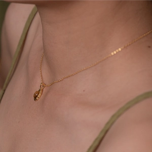 Collier en argent S925 avec pendentif ambre ovale sur chaîne dorée porté par un mannequin